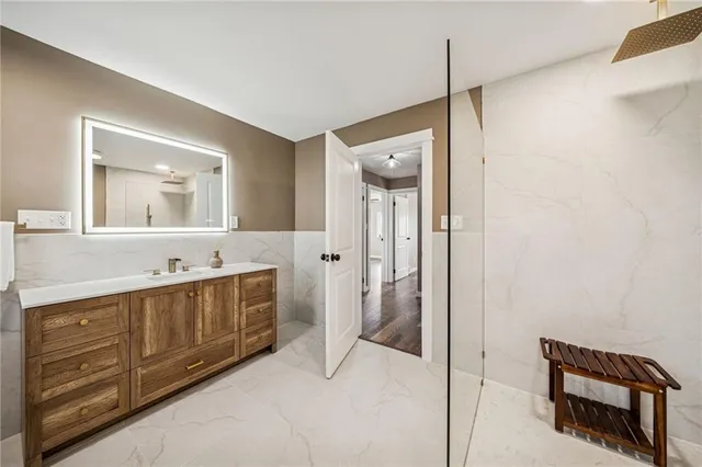 a spacious bathroom with a double vanity sink a mirror and a shower