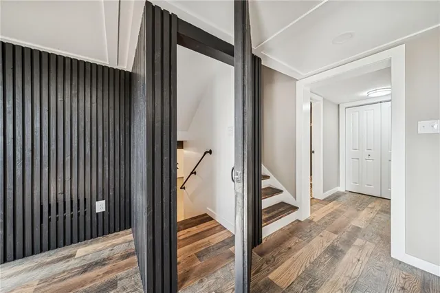 a view of a hallway with wooden floor and staircase