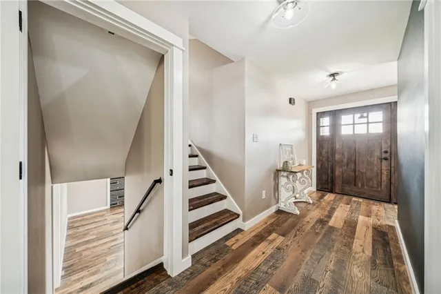 a view of a hallway with entryway and stairs