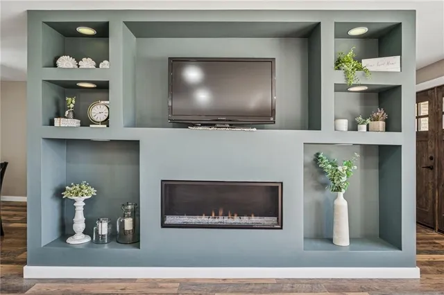 a living room with a fireplace and a potted plant