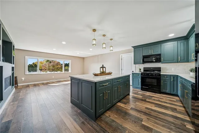 a kitchen with stainless steel appliances granite countertop a stove a sink and a refrigerator