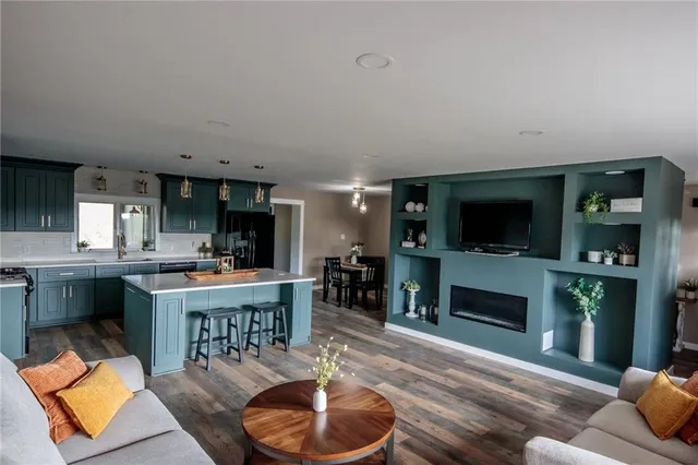 a living room with furniture a flat screen tv and a fireplace