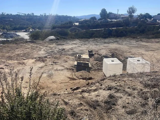 a view of a dry yard with wooden fence