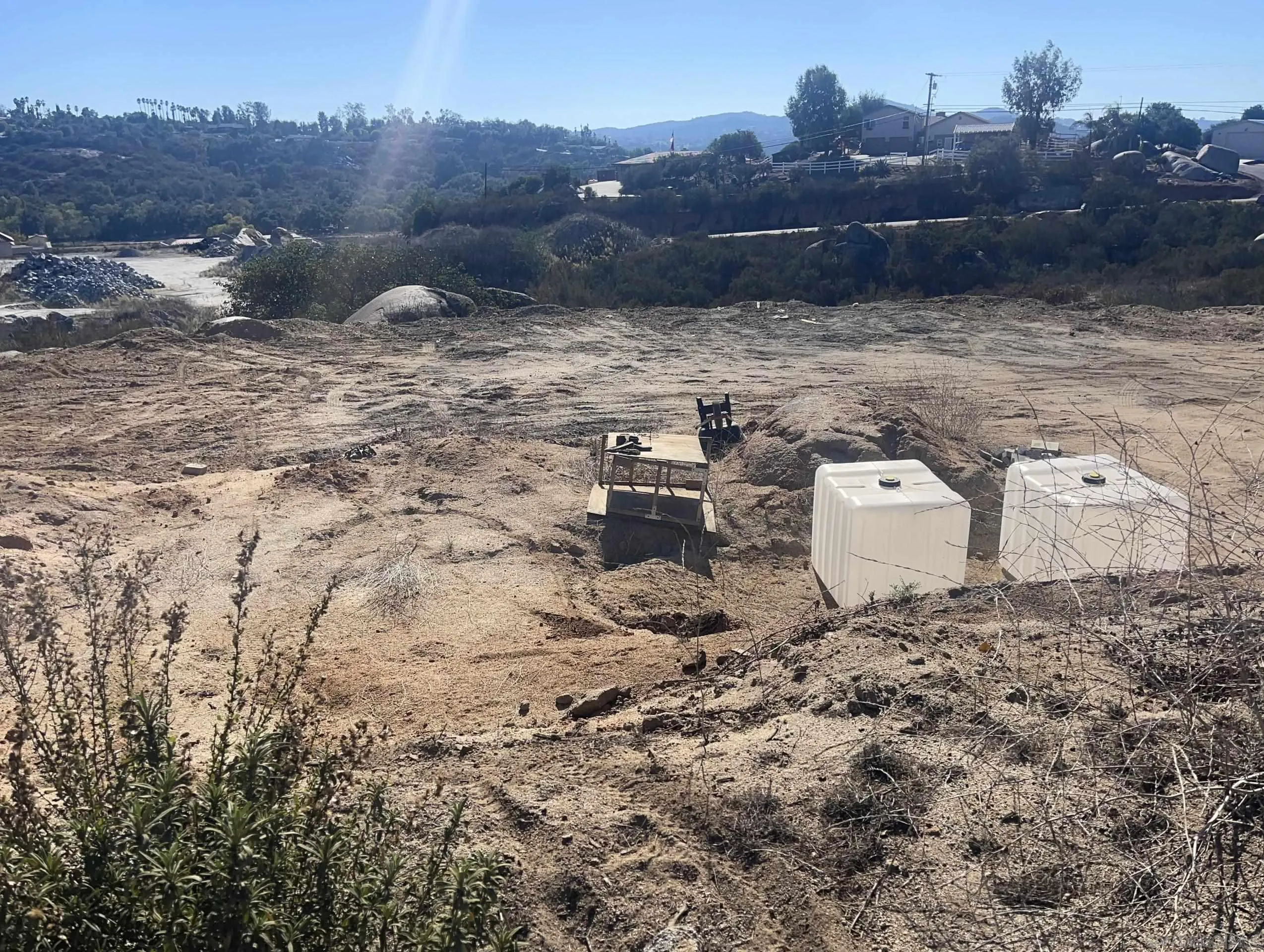 a view of a dry yard with wooden fence