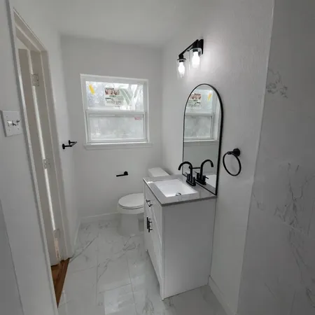 a bathroom with a toilet a sink and mirror