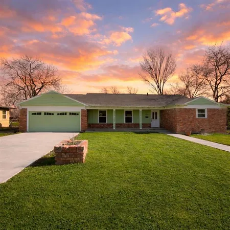 a front view of a house with a garden and yard