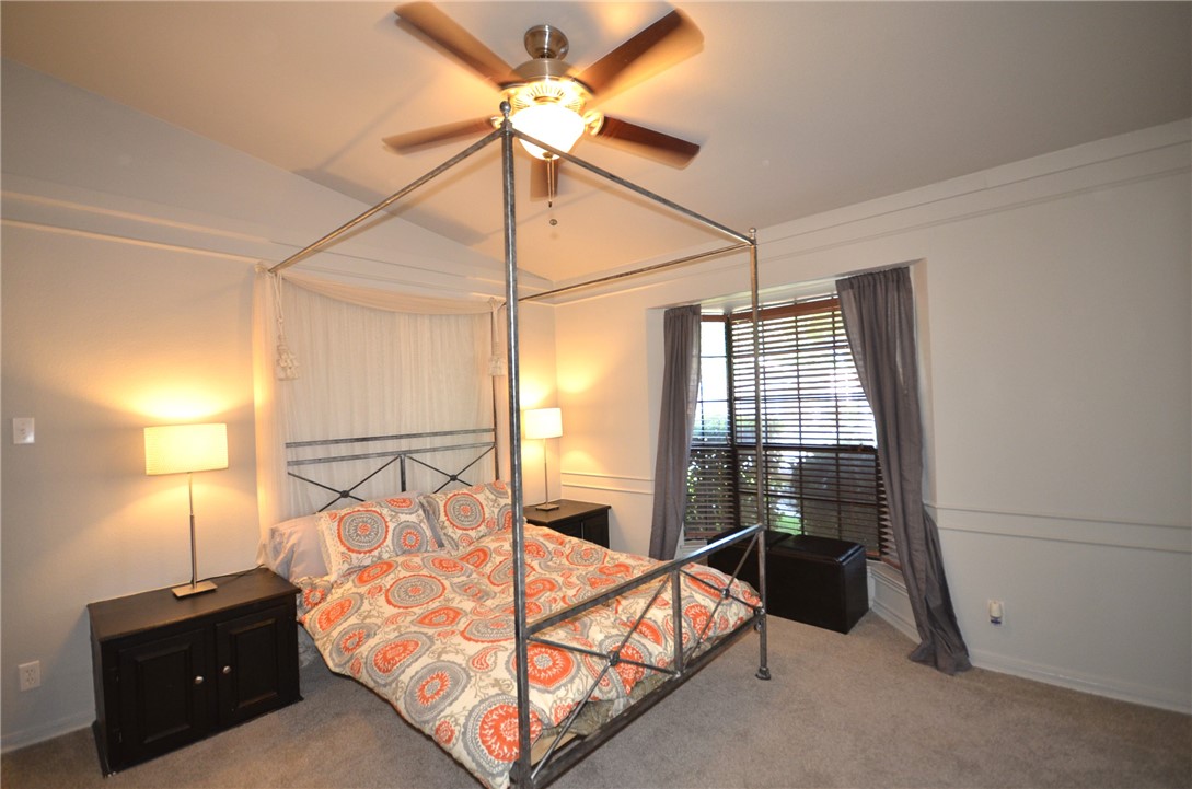 1601 Faro Drive, Unit 201 Austin, TX 78741 - Photo 15 of 24 a bedroom with a bed and a chandelier