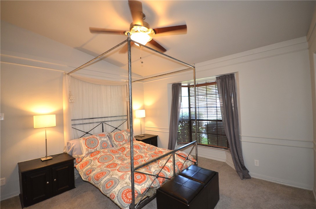 1601 Faro Drive, Unit 201 Austin, TX 78741 - Photo 16 of 24 a bedroom with a bed and a chandelier