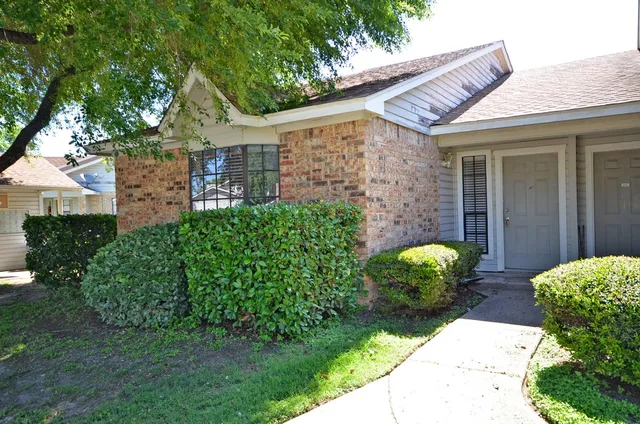 a tree in front of a white house