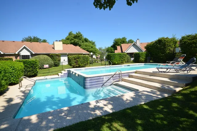 a view of a swimming pool with chairs in patio