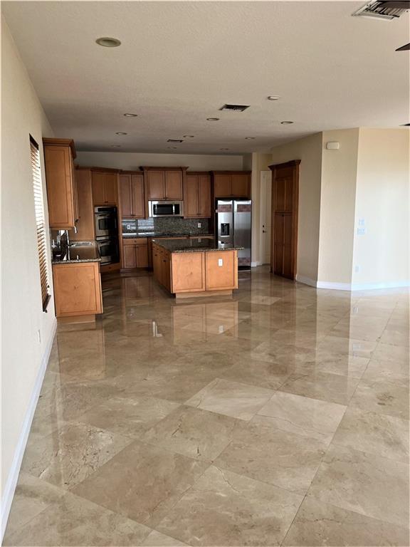 17989 Southwest 54th Street Miramar, FL 33029 - Photo 13 of 53 a kitchen with stainless steel appliances kitchen island granite countertop a sink and cabinets