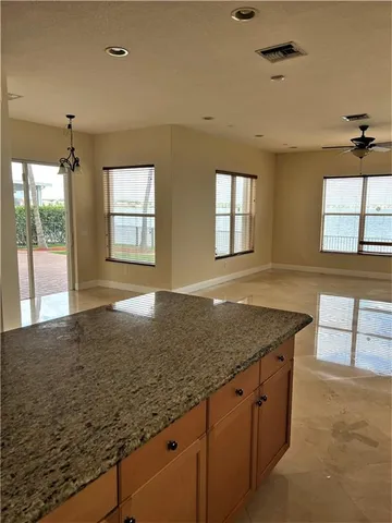 a kitchen with granite countertop a sink a stove and cabinets