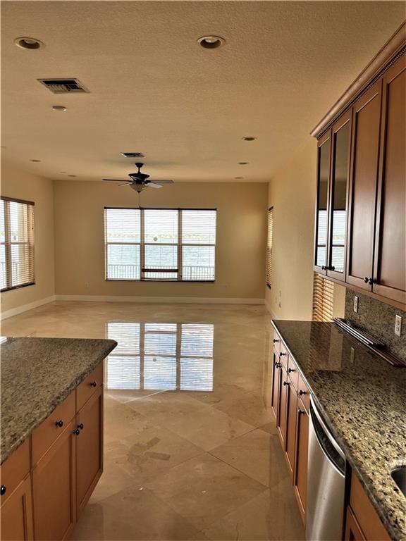 17989 Southwest 54th Street Miramar, FL 33029 - Photo 15 of 53 a kitchen with granite countertop a sink a stove and cabinets