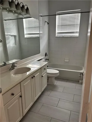 a bathroom with a double vanity sink toilet and a mirror