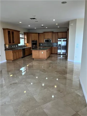 a view of a living room with kitchen view and a flat screen tv
