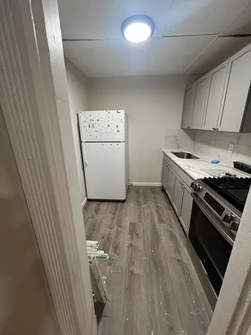 a utility room with wooden floor washer and dryer
