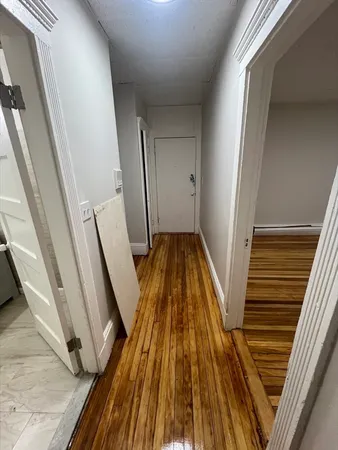 a view of a hallway with wooden floor and stairs