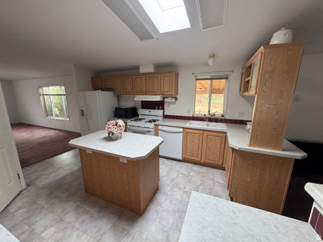 580 East 400 North Spring City, UT 84662 - Photo 10 of 40 Kitchen with light countertops, a kitchen island, white appliances, and a skylight