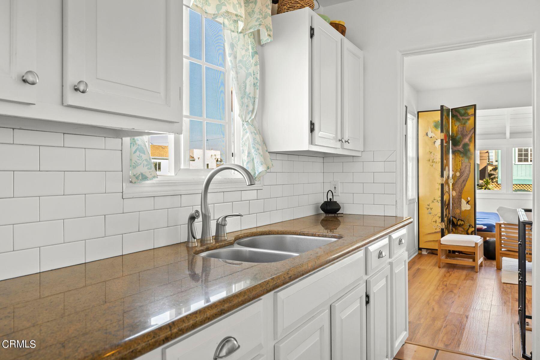 248 Cahuenga Drive Oxnard, CA 93035 - Photo 10 of 28 a kitchen with stainless steel appliances a sink a stove and white cabinets with wooden floor
