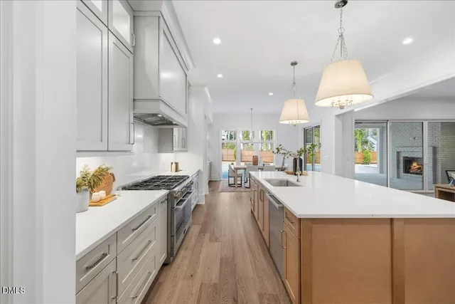 a view of a hallway with wooden floor and a bathroom