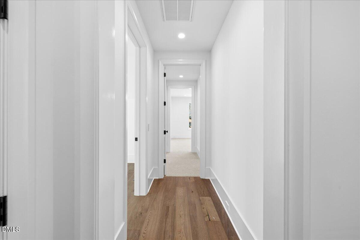 7309 Grist Mill Road Raleigh, NC 27615 - Photo 61 of 73 a view of a hallway with wooden floor and a bathroom