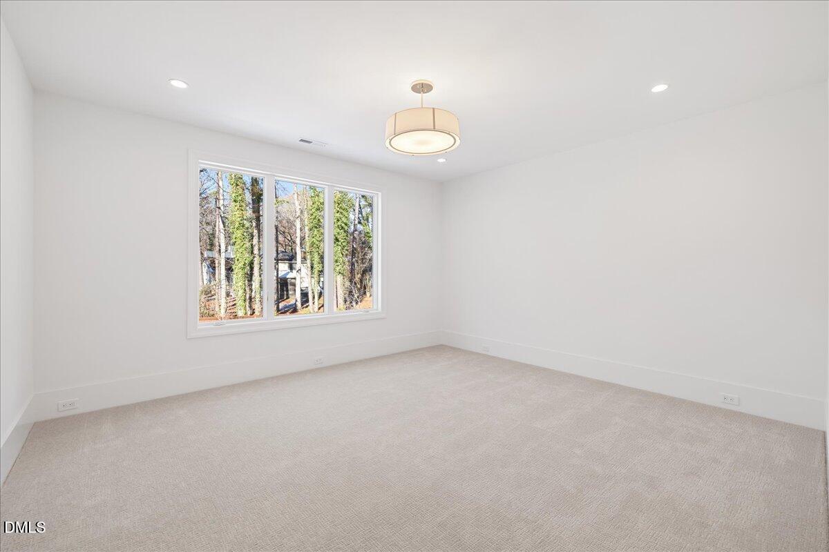 7309 Grist Mill Road Raleigh, NC 27615 - Photo 66 of 73 an empty room with a window and a ceiling fan