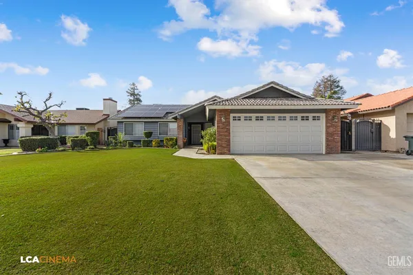 a front view of a house with a garden and yard