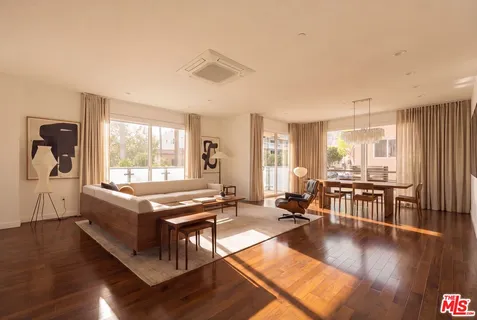 a living room with a table chairs stove and wooden floor