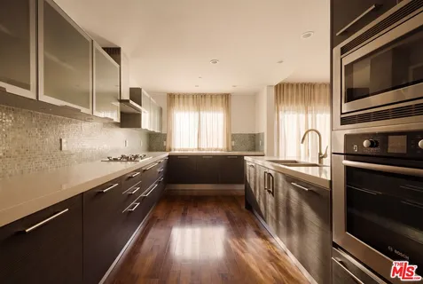 a kitchen with granite countertop stainless steel appliances and wooden cabinets