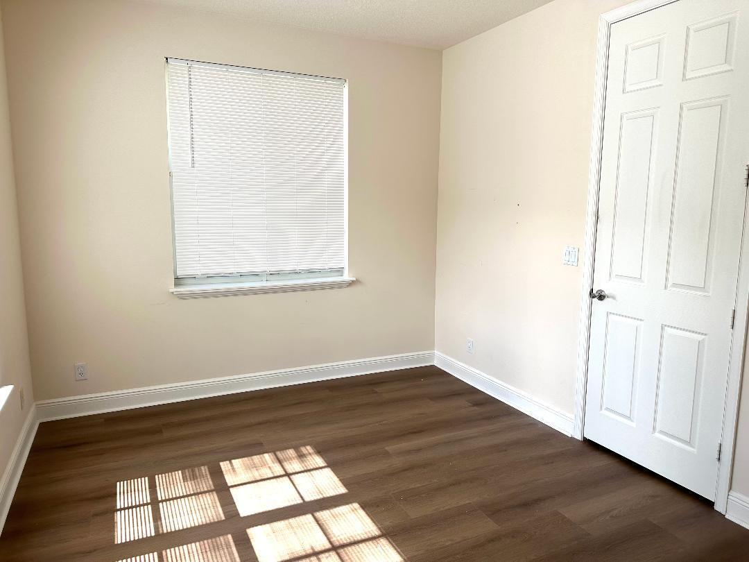 808 University Boulevard Jupiter, FL 33458 - Photo 13 of 16 an empty room with wooden floor and windows