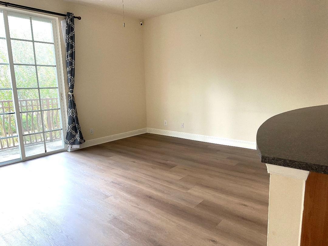 808 University Boulevard Jupiter, FL 33458 - Photo 5 of 16 an empty room with wooden floor and windows