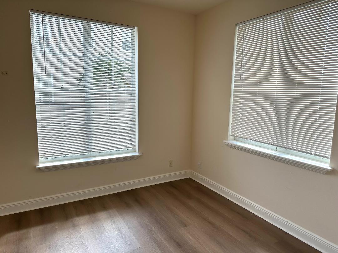 808 University Boulevard Jupiter, FL 33458 - Photo 9 of 16 a view of an empty room with wooden floor and a window