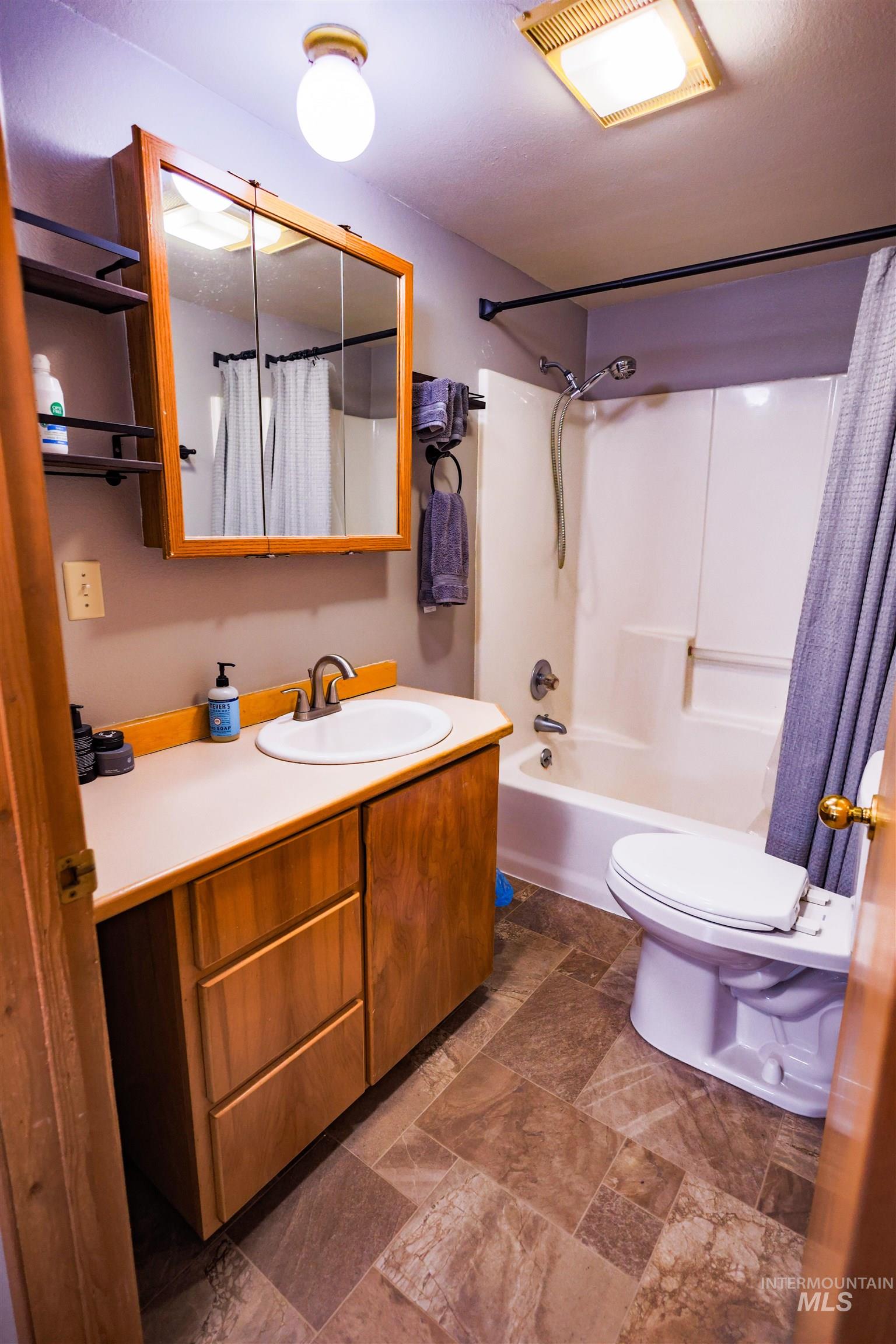 515 8th Street Kamiah, ID 83536 - Photo 16 of 31 Bathroom featuring a wood-finish vanity with a laminate countertop and integrated sink