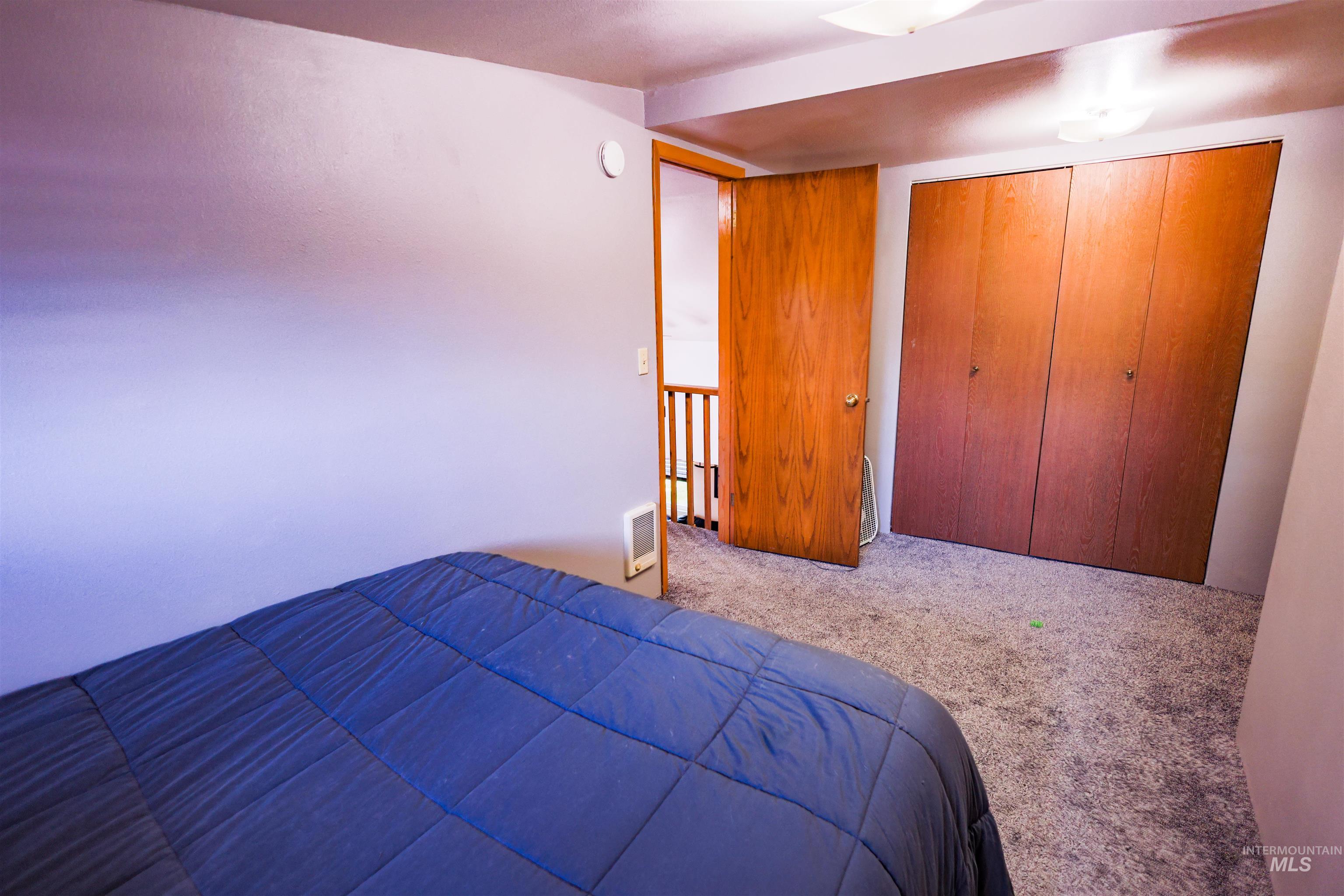 515 8th Street Kamiah, ID 83536 - Photo 18 of 31 Carpeted room featuring a ceiling-mounted light fixture, wood-finish doors, and a wall-mounted heating unit