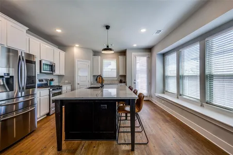 a kitchen with stainless steel appliances granite countertop a sink a stove and a refrigerator
