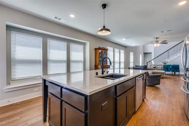 a kitchen with stainless steel appliances granite countertop sink stove and wooden floor