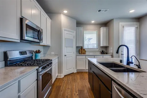 a kitchen with stainless steel appliances granite countertop a sink a stove and cabinets