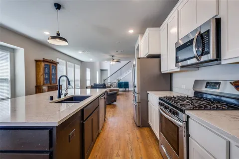 a kitchen with stainless steel appliances granite countertop a sink stove and cabinets