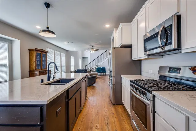 a kitchen with stainless steel appliances granite countertop a sink stove and cabinets