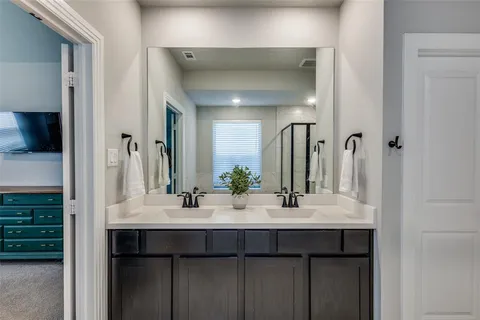 a bathroom with a double vanity sink and a mirror