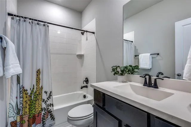 a bathroom with a sink a toilet a tub and shower