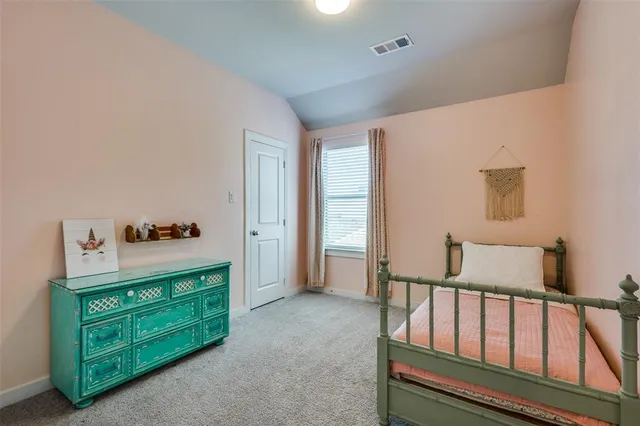 a spacious bedroom with a bed and a dresser