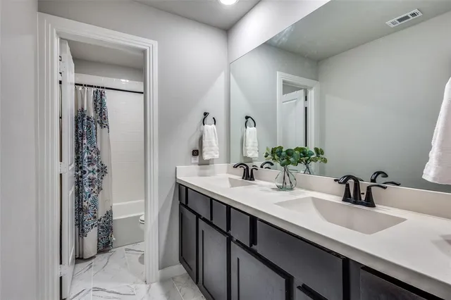 a bathroom with a double vanity sink and a mirror
