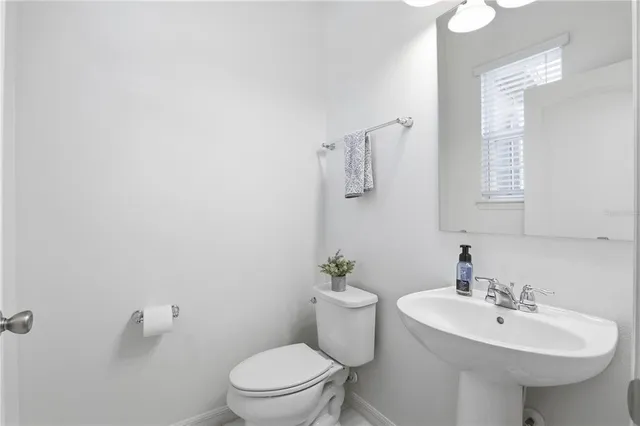 a bathroom with a sink a toilet and mirror
