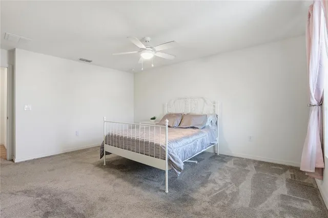 a white bed sitting in a room next to a window