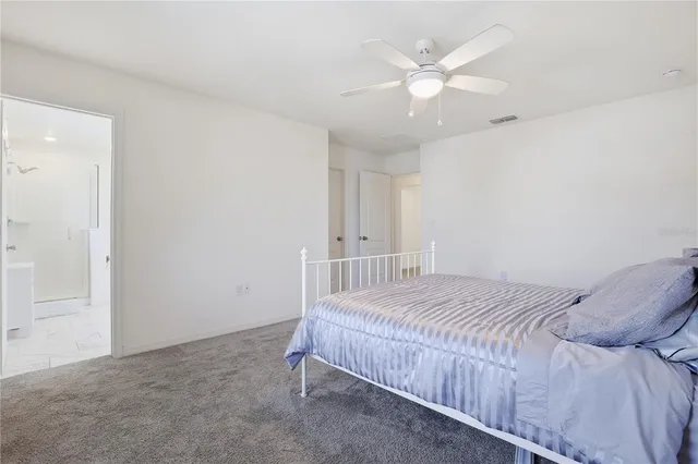 a bedroom with a bed and a ceiling fan