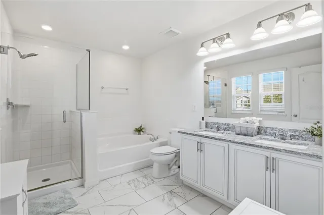 a bathroom with a granite countertop sink a toilet a mirror and shower