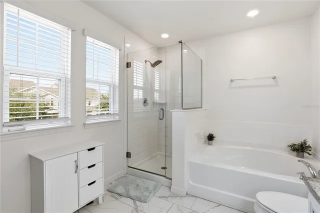 a bathroom with a tub shower sink and mirror
