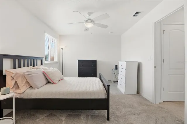 a bedroom with a bed and a ceiling fan