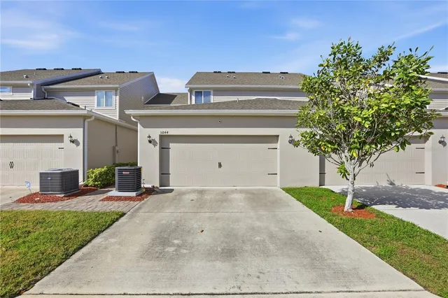 a view of a house with a yard and potted plants